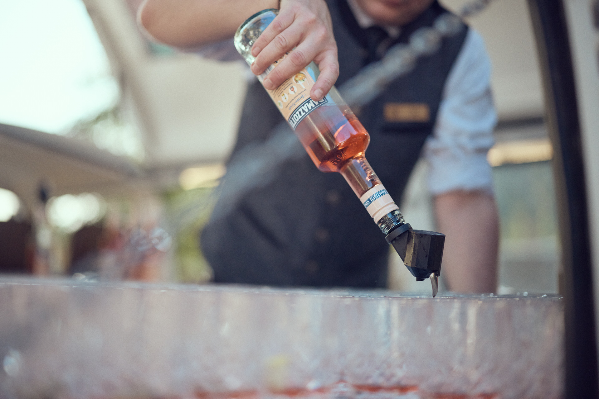 Ein Barkeeper schenkt ein alkoholisches Getränk in Gläser ein
